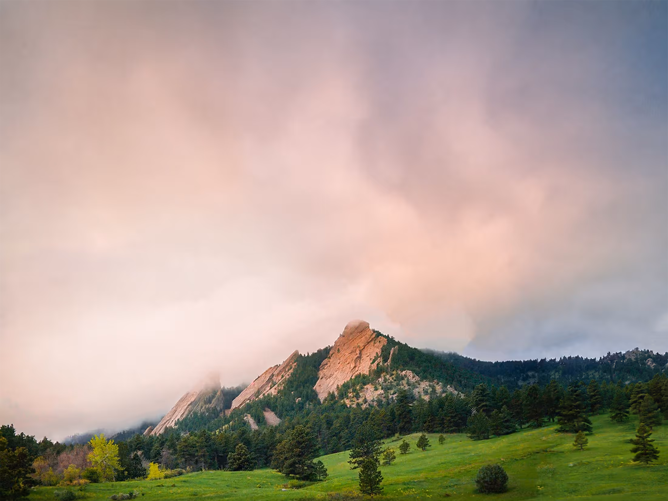 Cloud coming down over the Flatirons above a spring meadow