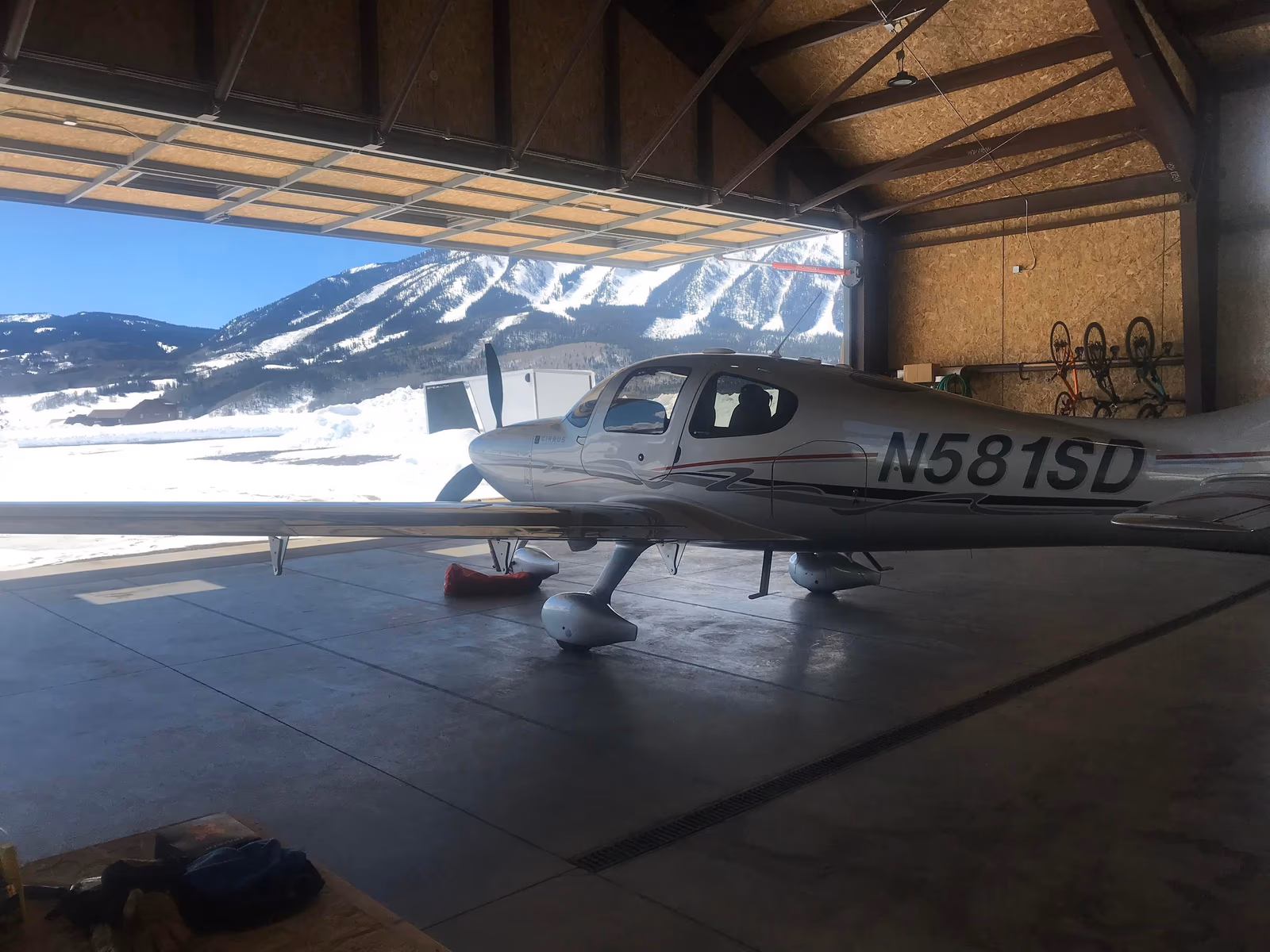 A modern hangar home with a large paved apron and mountain views.