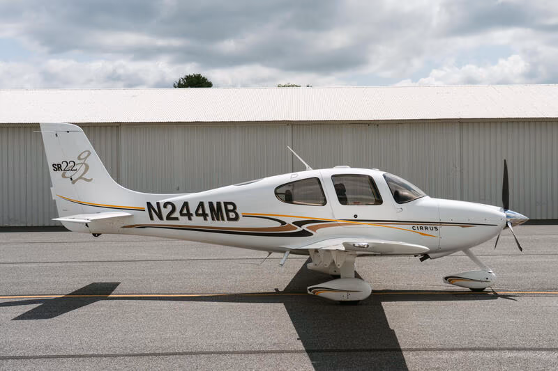 A Cirrus SR22 parked on the ramp beside a row of hangars at Parkland Estates.