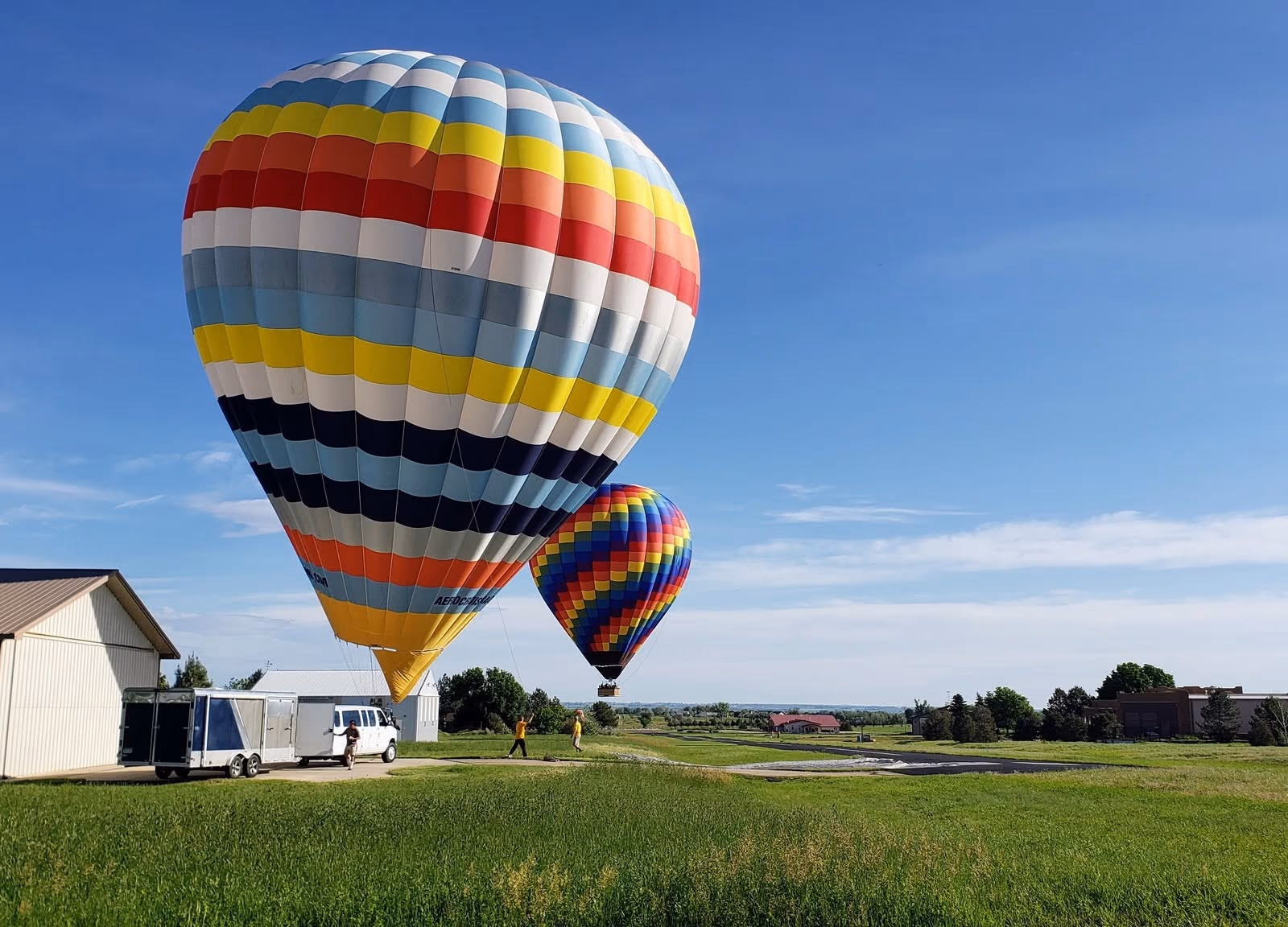 A hot-air balloon launching beside a hangar at Parkland Estates.