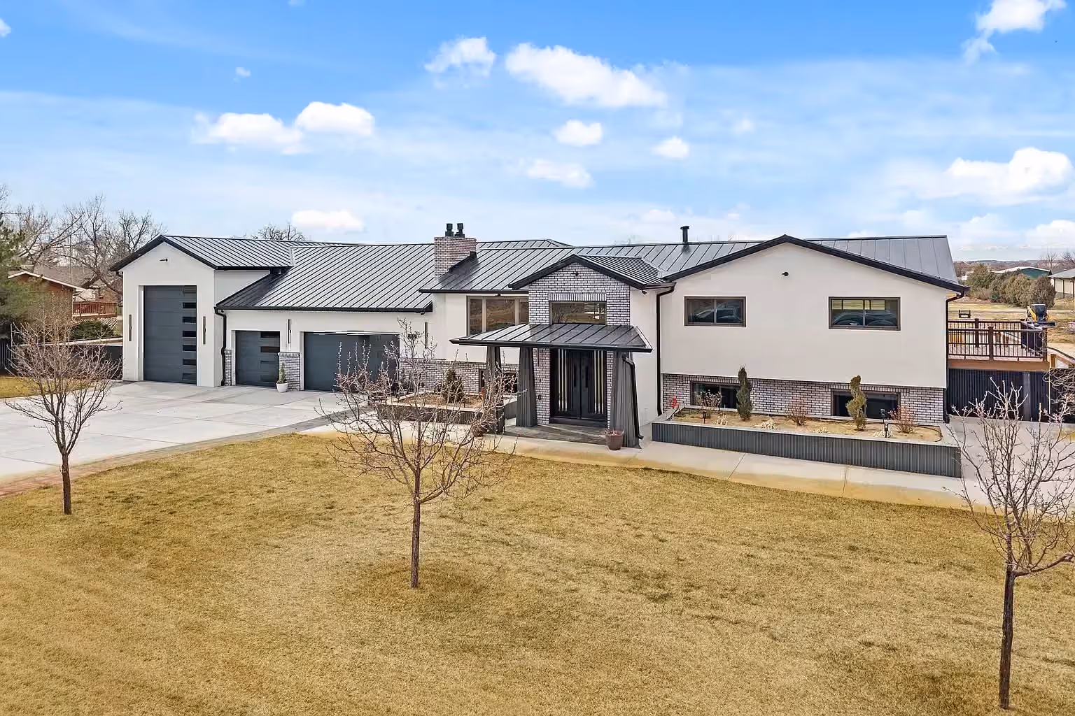 A modern white farmhouse-style home with an attached hangar at Van Aire.