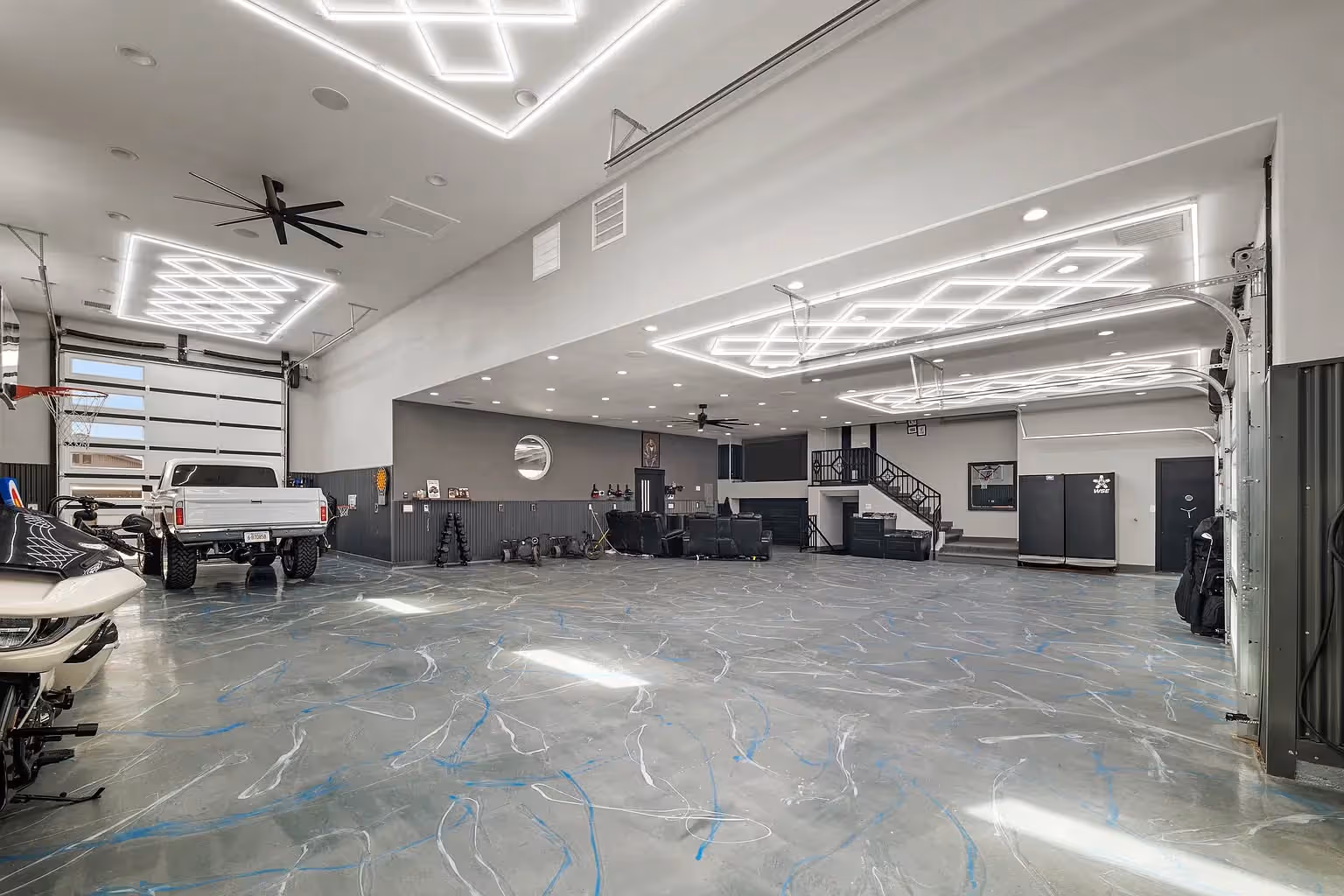 A bright hangar interior with a truck parked on a marble-effect floor.