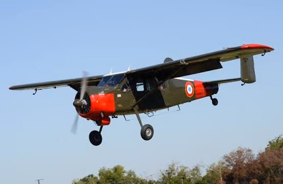A vintage high-wing taildragger photographed low over the airfield.