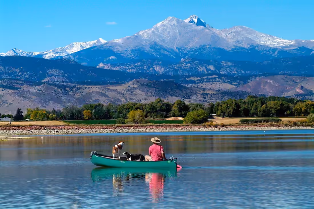 A canoe on still water below Longs Peak