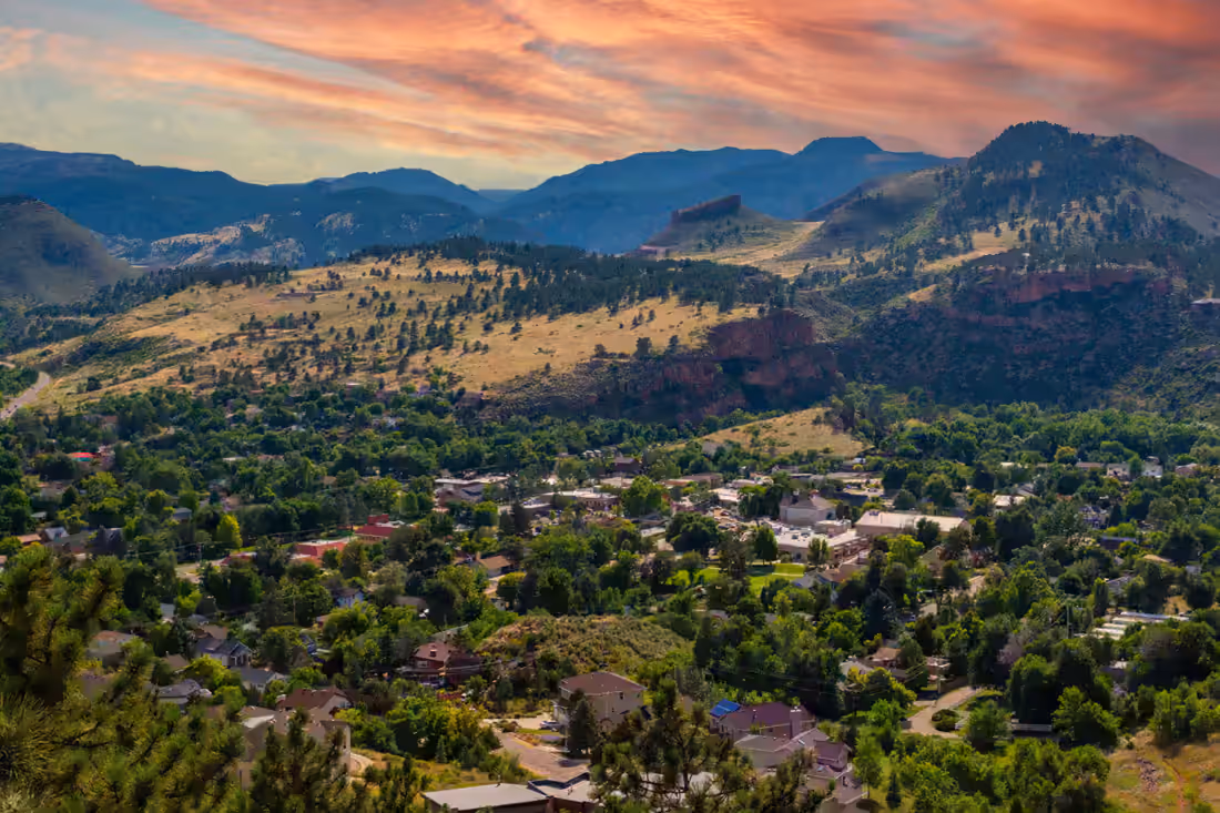 The town in its valley at sunset with red sandstone hogbacks rising behind it