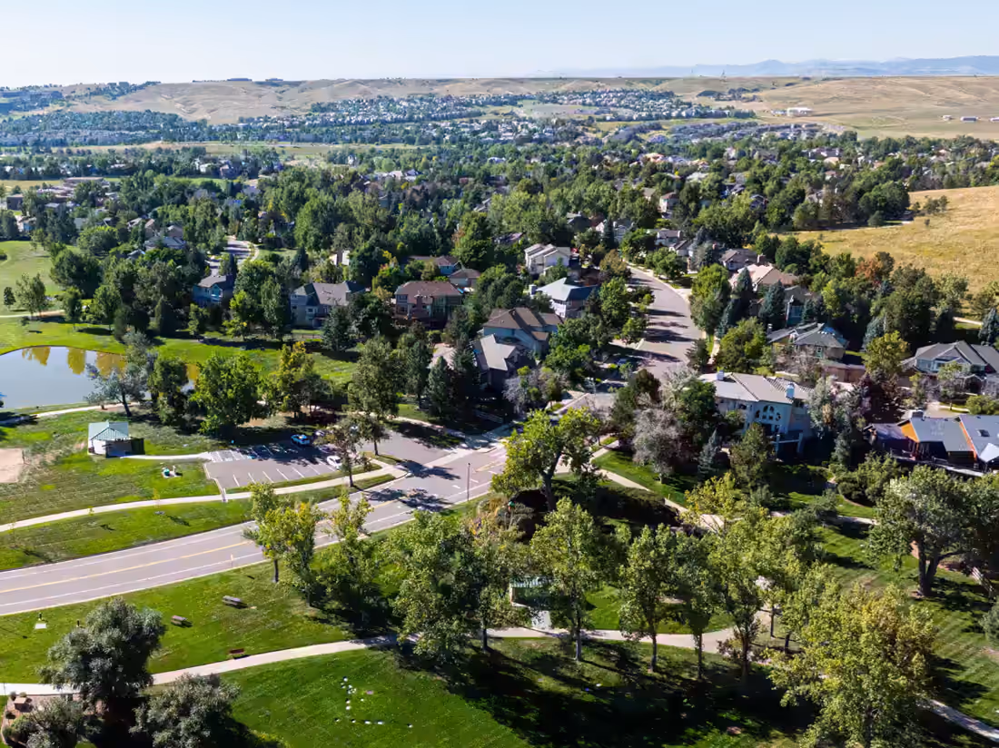 Residential streets running up against open grassland hills