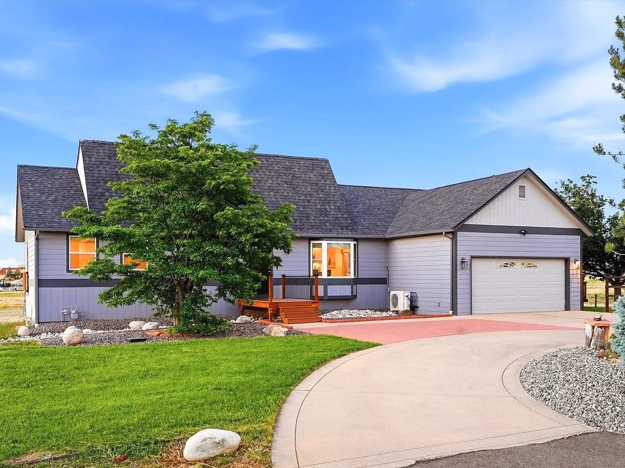 A single-storey home with dormers and a two-car garage on a curved private drive in the Erie airpark neighborhood.